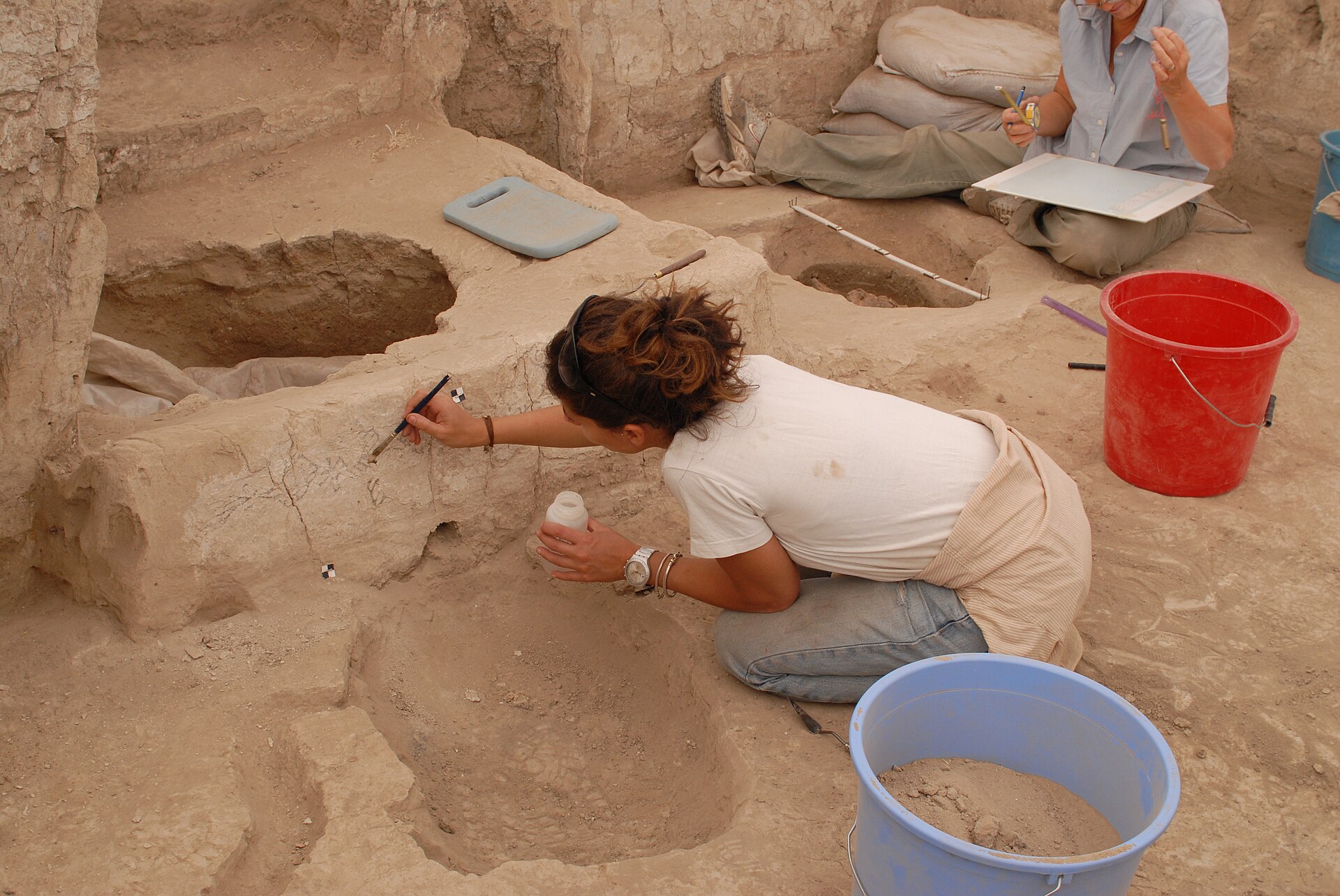Conservators recording and treating a plastered surface during fieldwork at Çatalhöyük